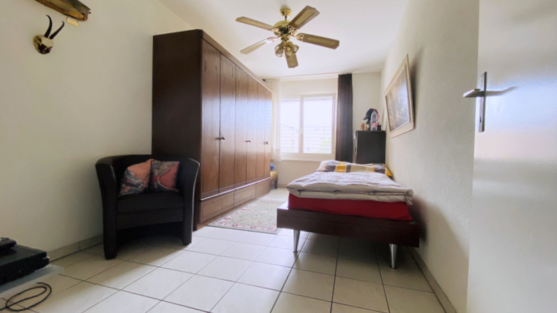 Schlafzimmer mit Einzelbett und großem Kleiderschrank