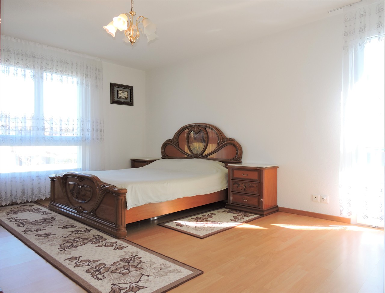 Helles Schlafzimmer mit klassischem Holzbett