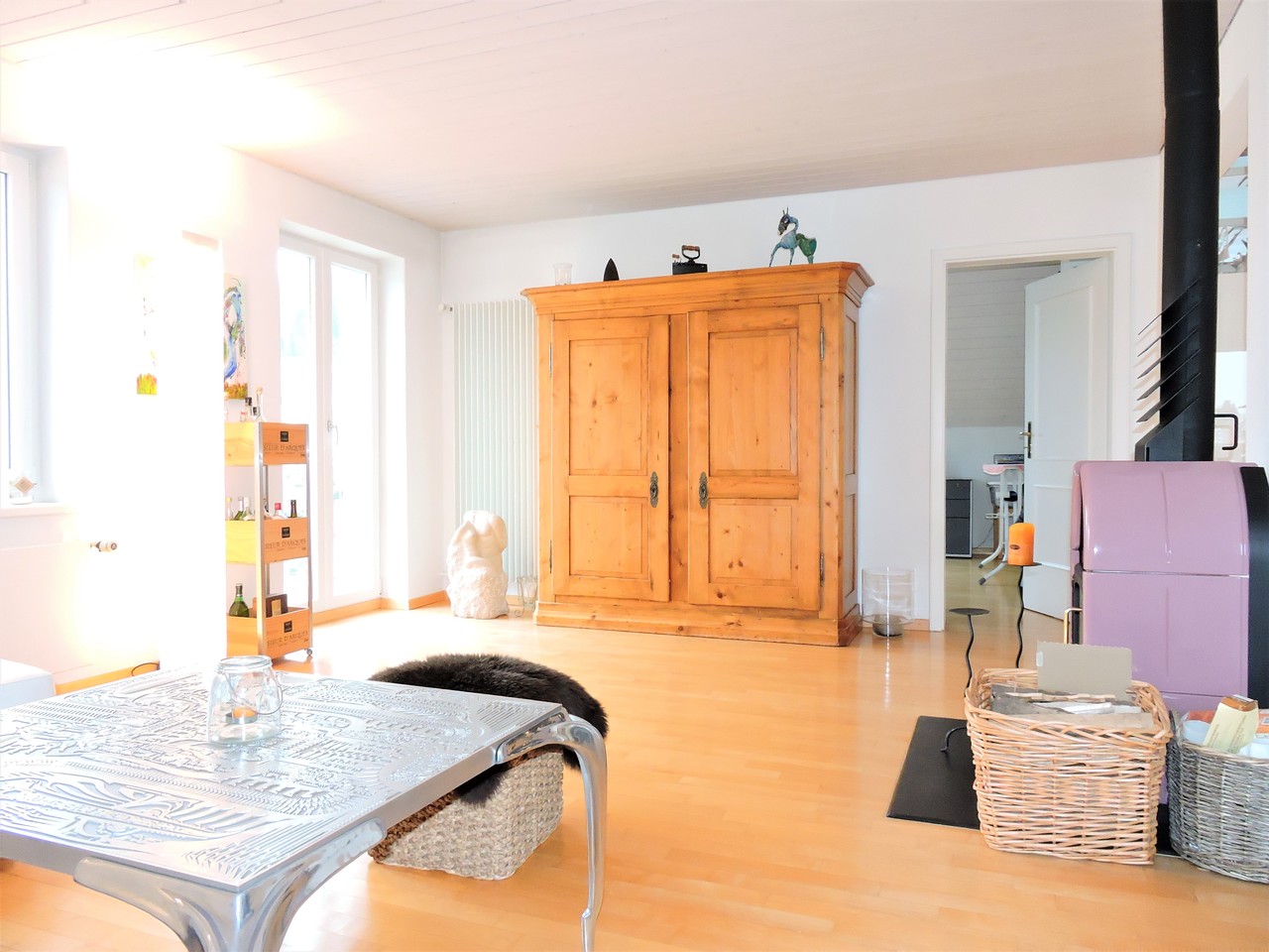 Helles Wohnzimmer mit Holzschrank und Pastellakzenten