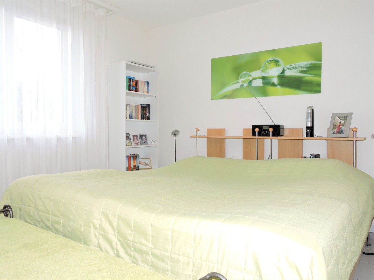 Helles Schlafzimmer mit Doppelbett und Regal