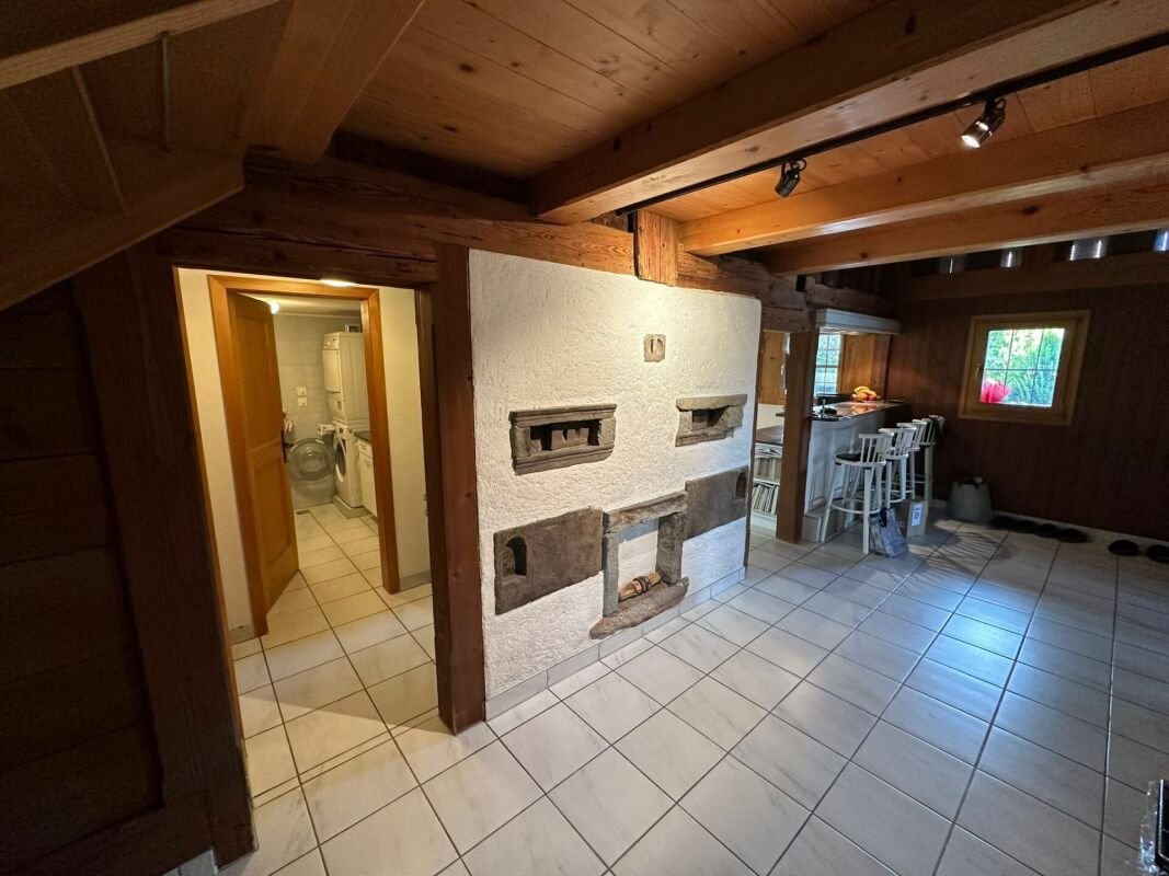 Rustikaler Wohnraum mit Holzdecke und Kaminwand