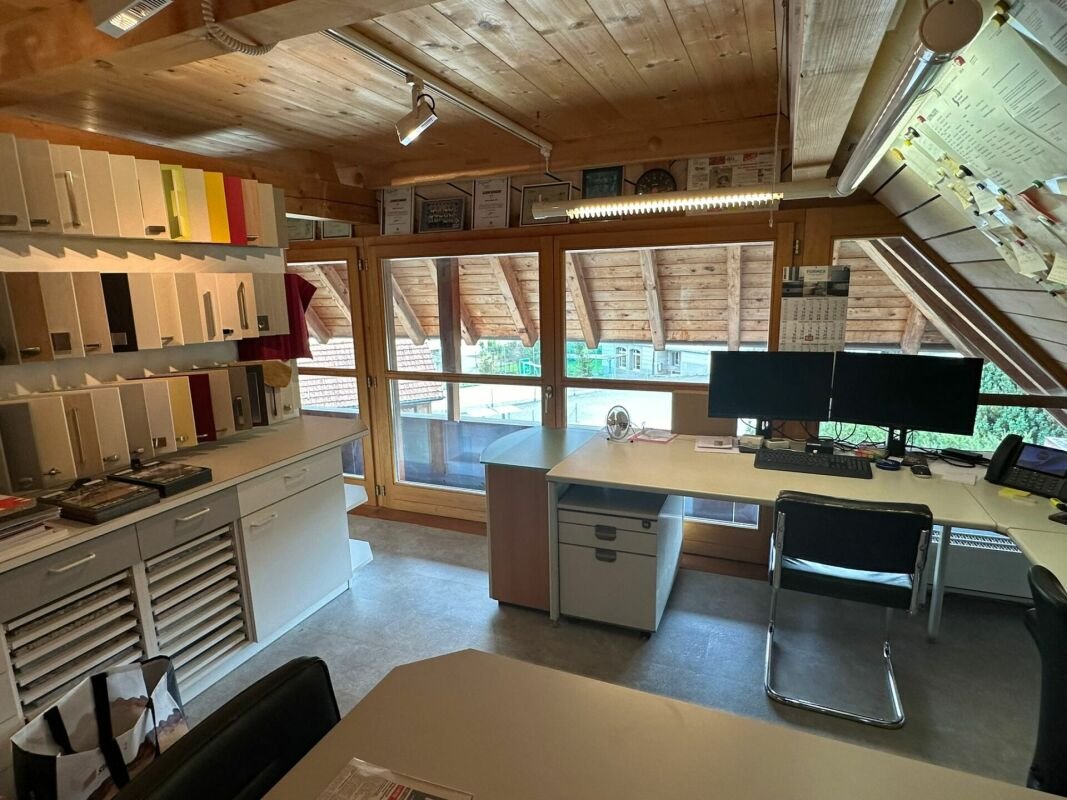 Büro mit Holzdecke und großen Fenstern