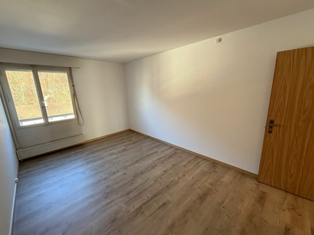Leeres Schlafzimmer mit Fenster und Holztür