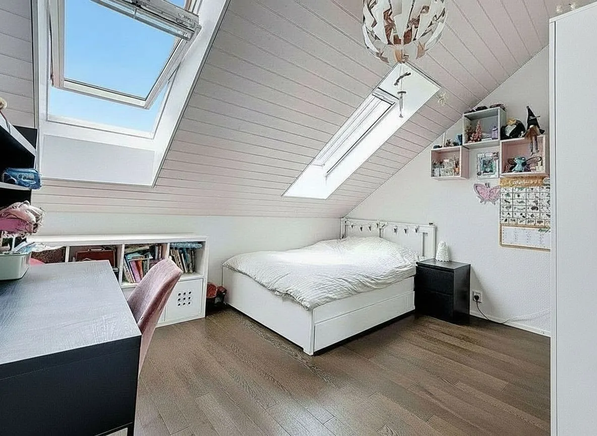 Dachzimmer mit Bett und Arbeitsplatz