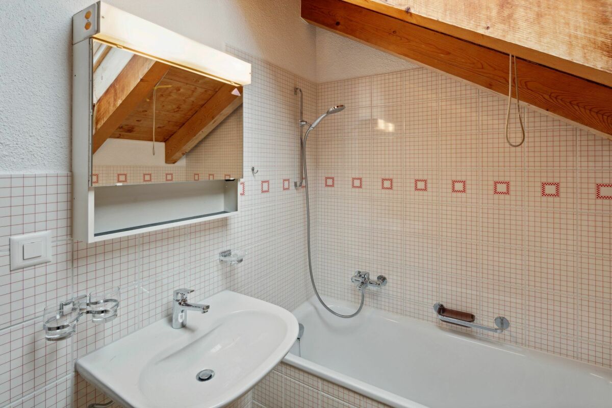 Dachgeschoss-Badezimmer mit Badewanne und Waschbecken