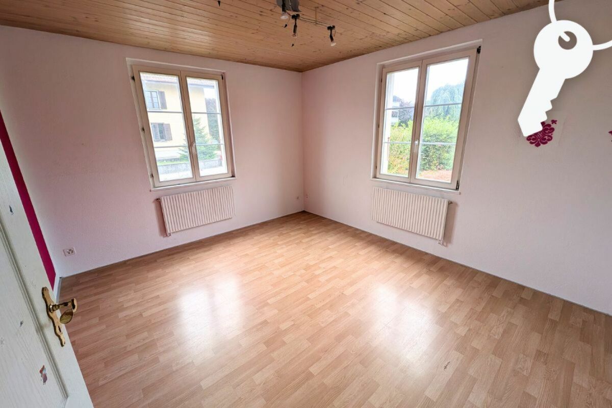 Helles, leeres Zimmer mit zwei Fenstern