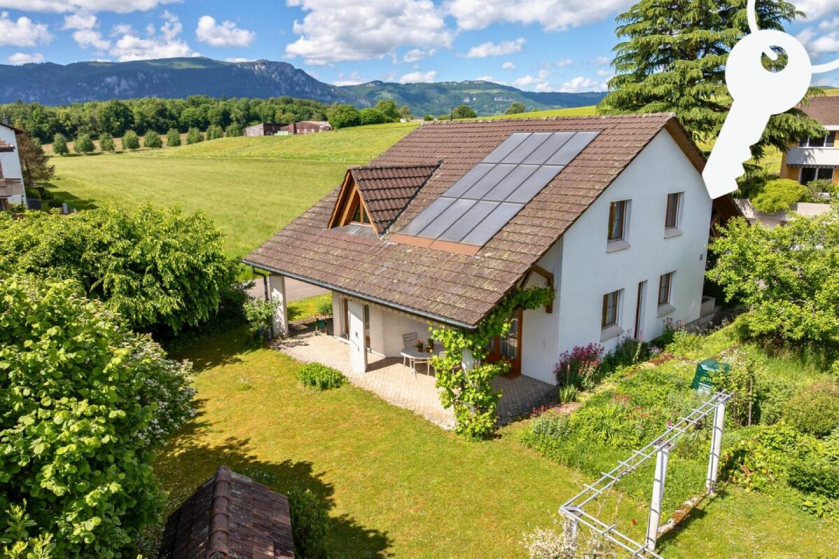 Einfamilienhaus mit Solarpaneelen und Gartenblick