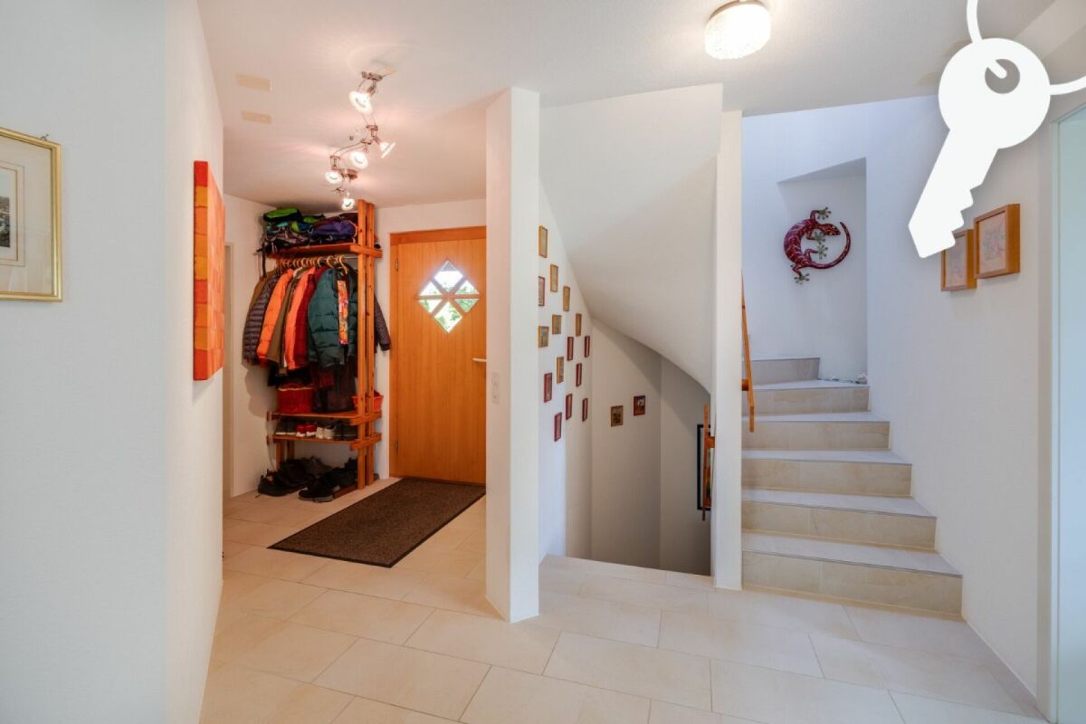 Heller Eingangsbereich mit Treppe und Garderobe