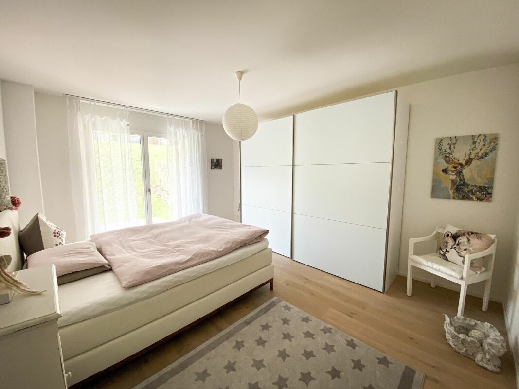 Helles Schlafzimmer mit großem Schiebefenster und Einbauschrank