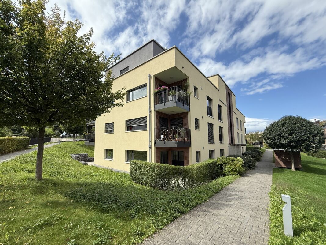 Mehrfamilienhaus mit Balkonen und Grünanlage
