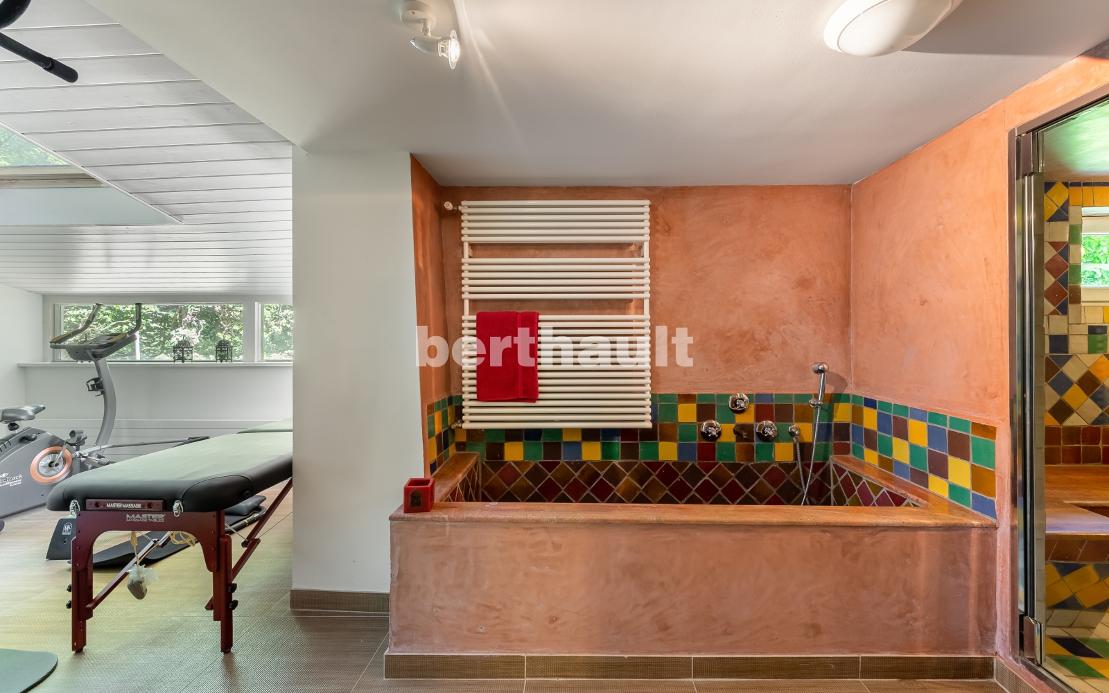 Wellnessbereich mit Badewanne und Sportraum