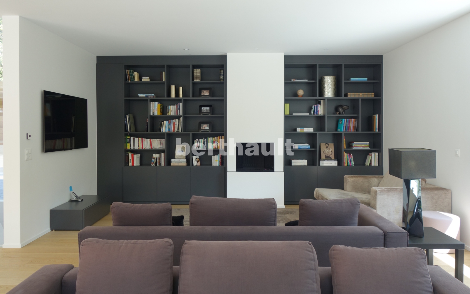 Modernes Wohnzimmer mit Bibliothekswand und Kamin