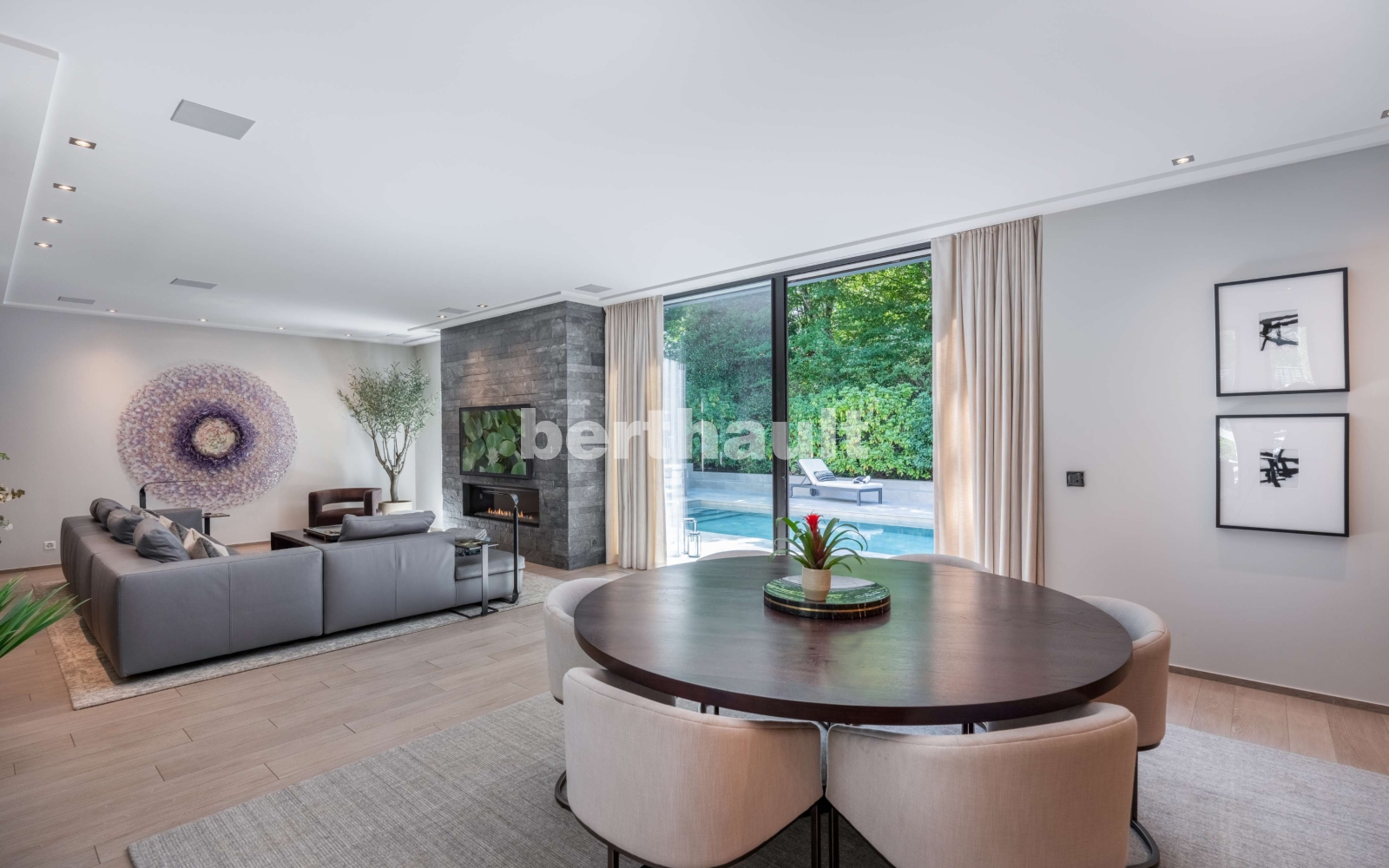 Offener Wohn- und Essbereich mit Kamin und Poolblick
