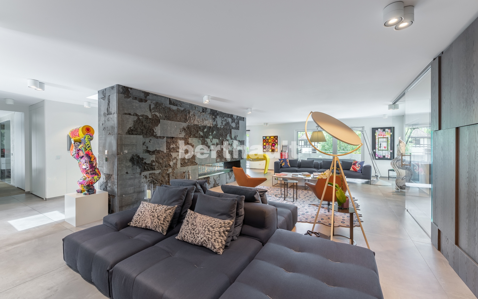Offener Wohnbereich mit Designkamin und Skulpturen