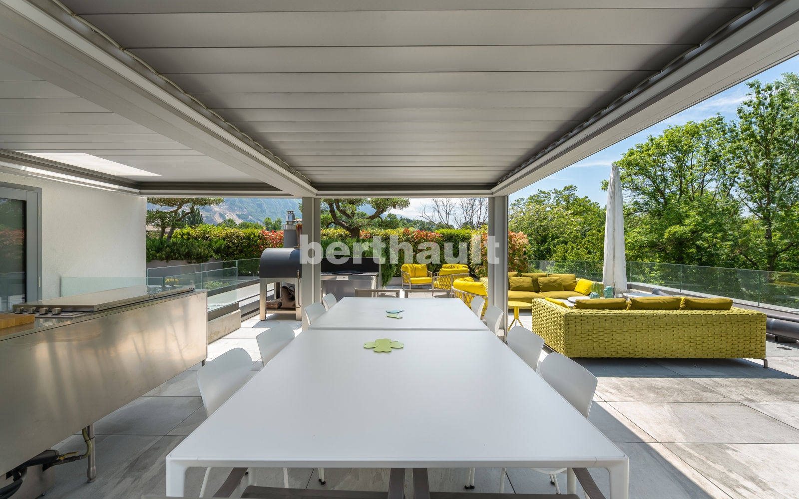 Überdachte Außenterrasse mit Lounge und Grillbereich