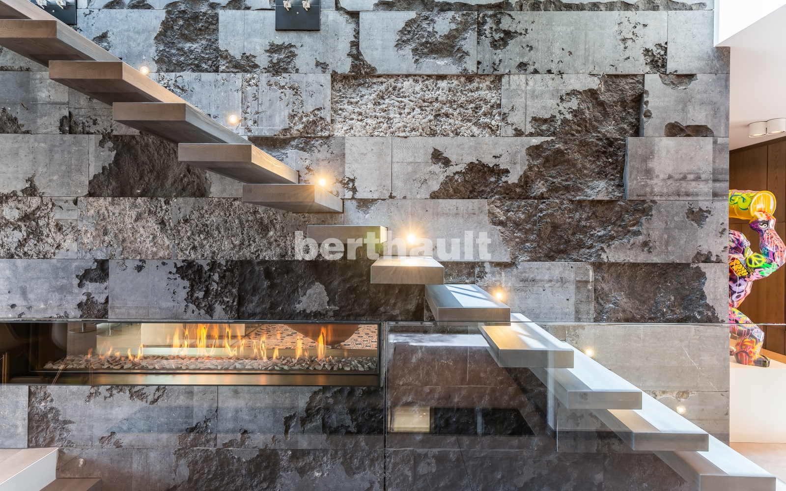 Moderne Treppe mit Natursteinwand und Kamin