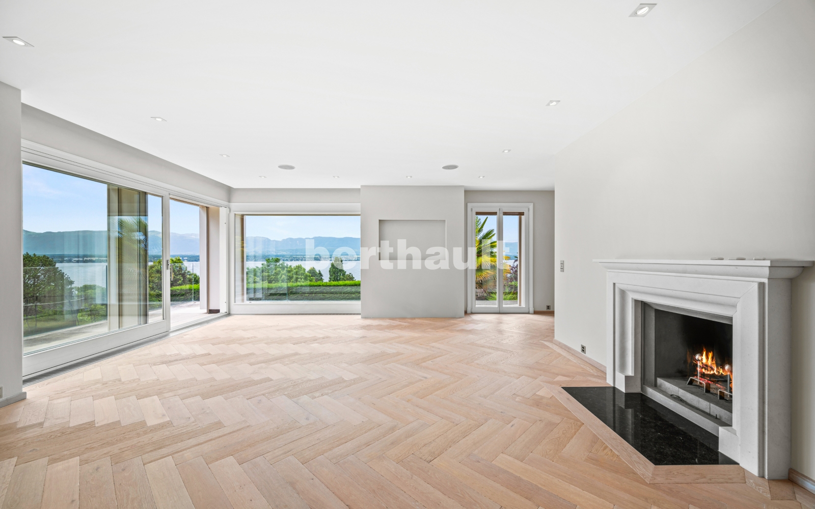 Großzügiges Wohnzimmer mit Kamin und Seeblick
