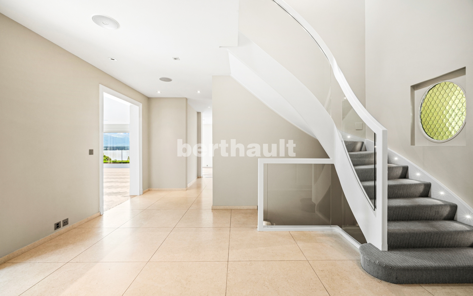 Heller Eingangsbereich mit geschwungener Treppe
