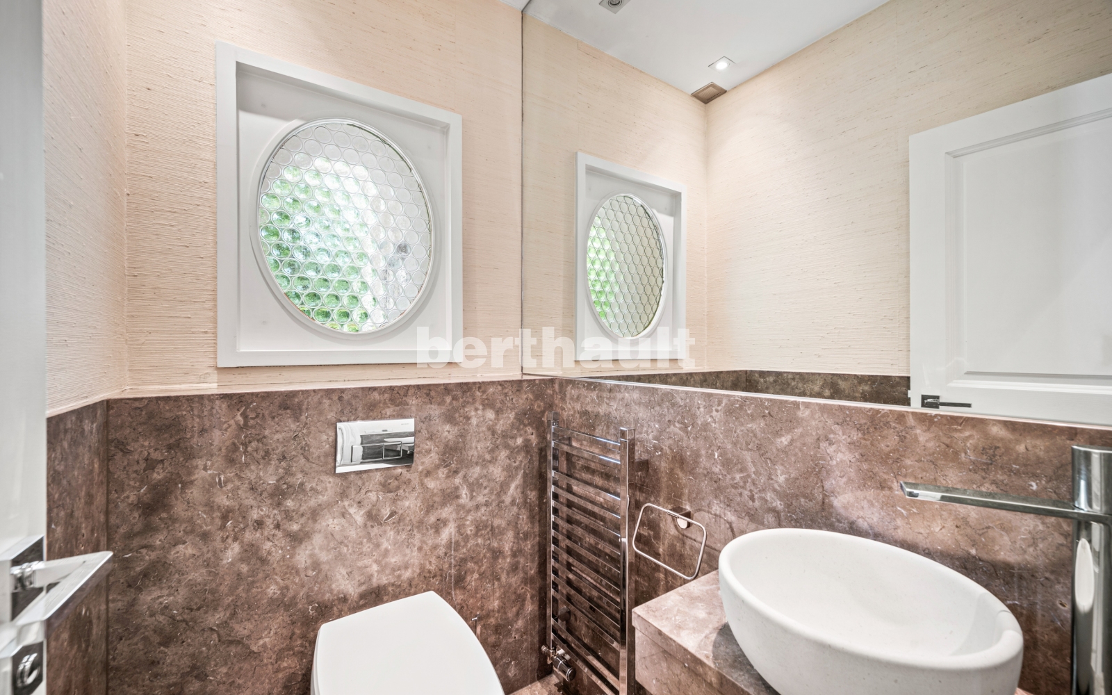 Gäste-WC mit ovalen Fenstern und Natursteinverkleidung