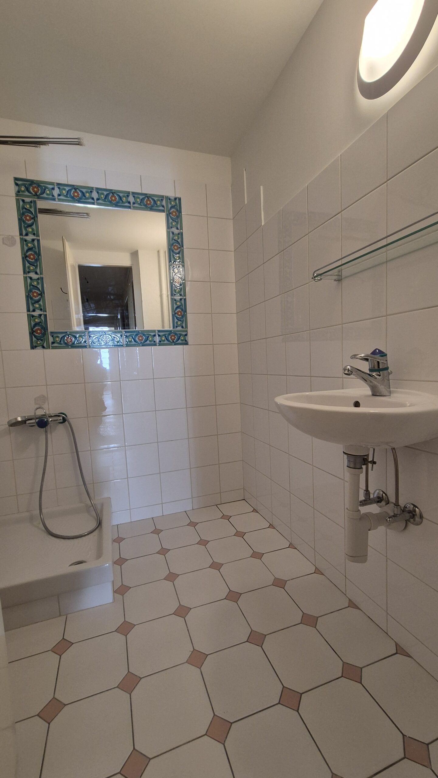 Kleines Badezimmer mit Dusche und Waschtisch