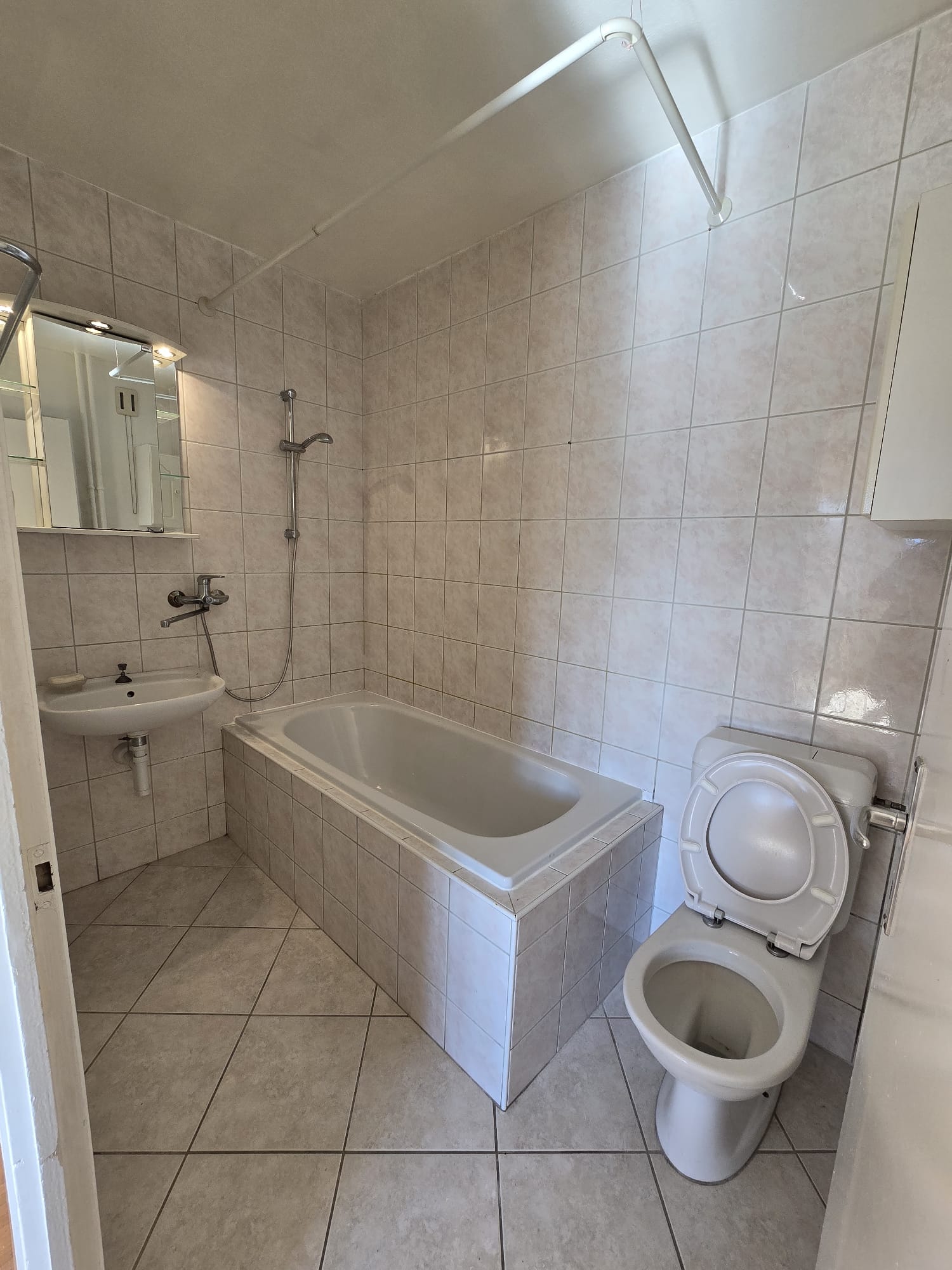 Kleines Badezimmer mit Badewanne und WC