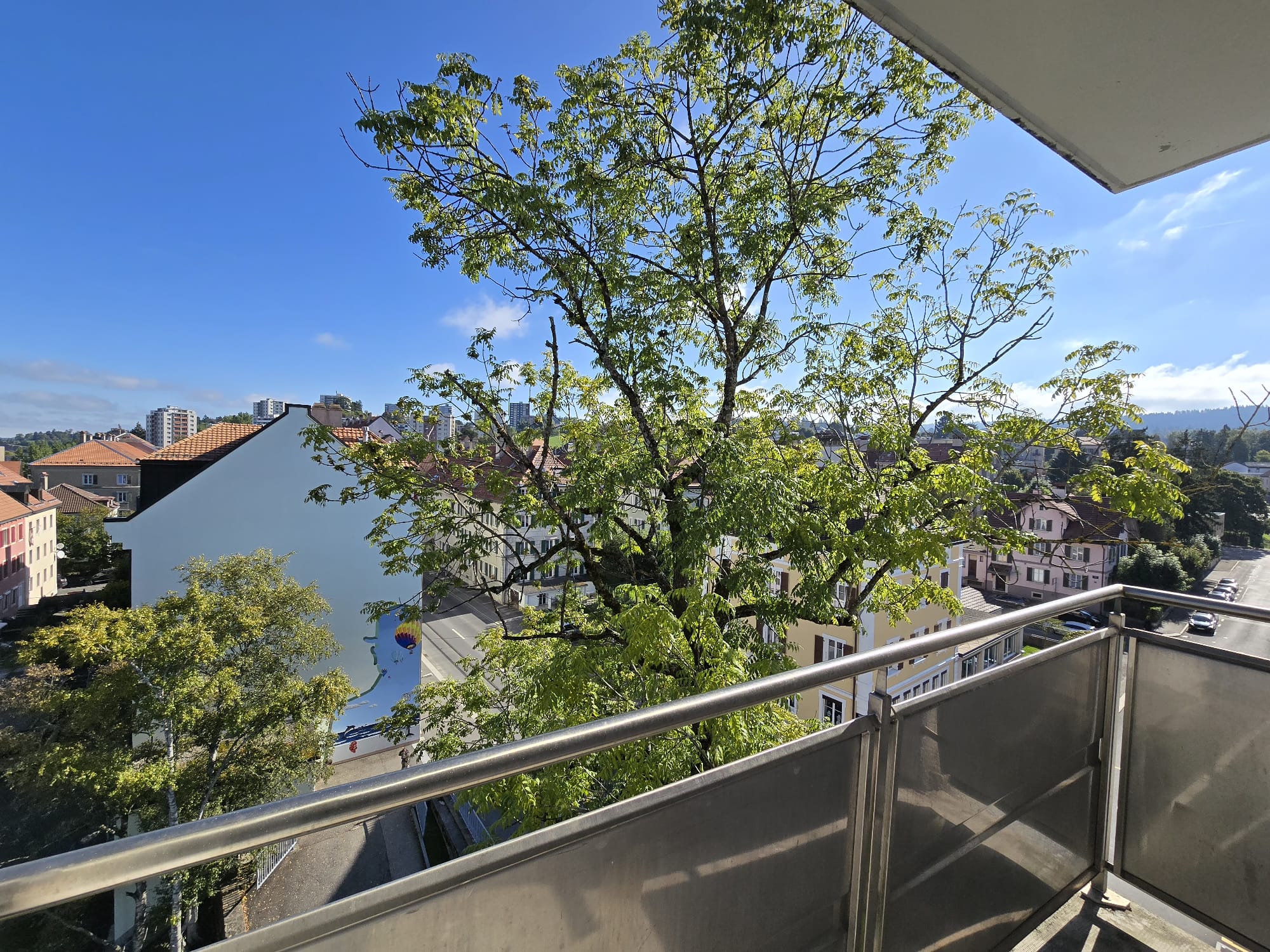 Balkonblick über ein grünes Stadtviertel