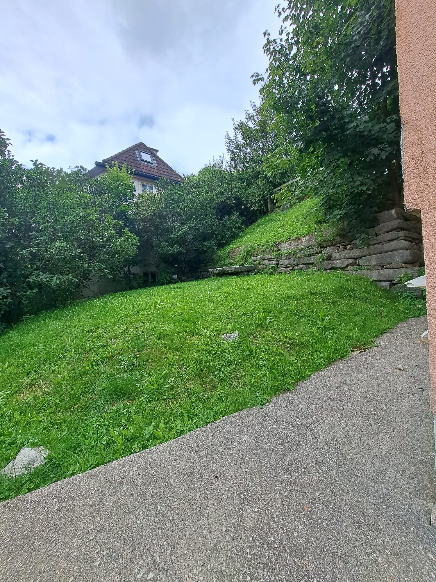 Garten mit Hanglage und Blick auf ein Haus