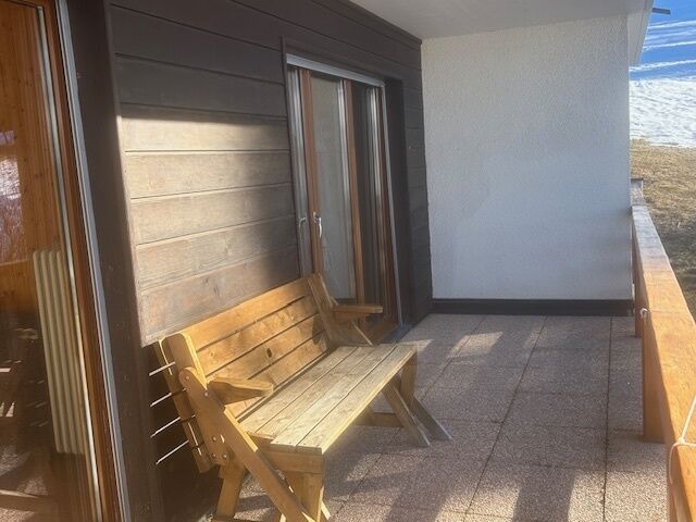 Balkon mit Holzbank und Seeblick