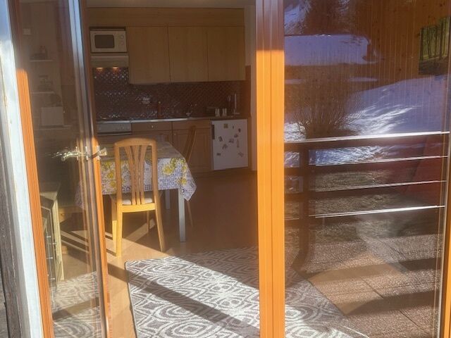 Blick durch eine Glasfront in einen kleinen Wohn-Essbereich