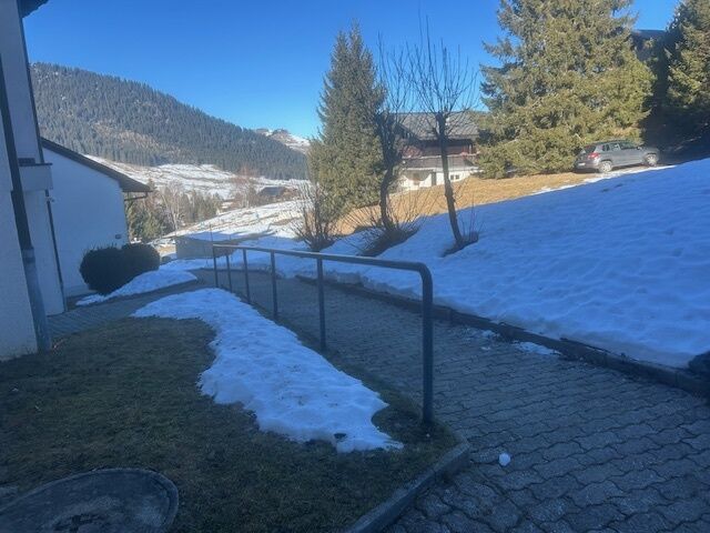 Außenansicht eines verschneiten Grundstücks mit Zufahrtsweg