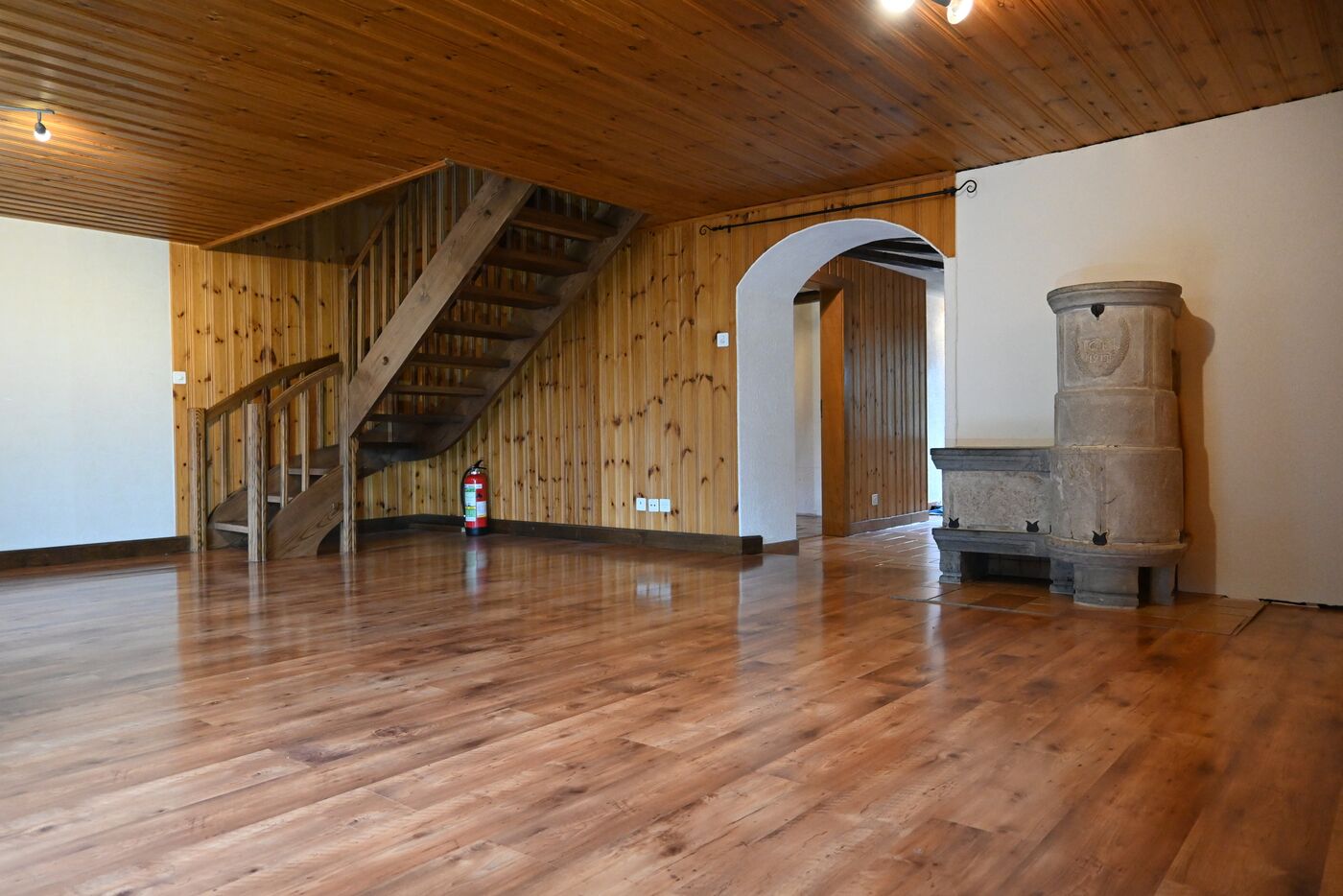 Großer Wohnraum mit Holzvertäfelung und Treppe