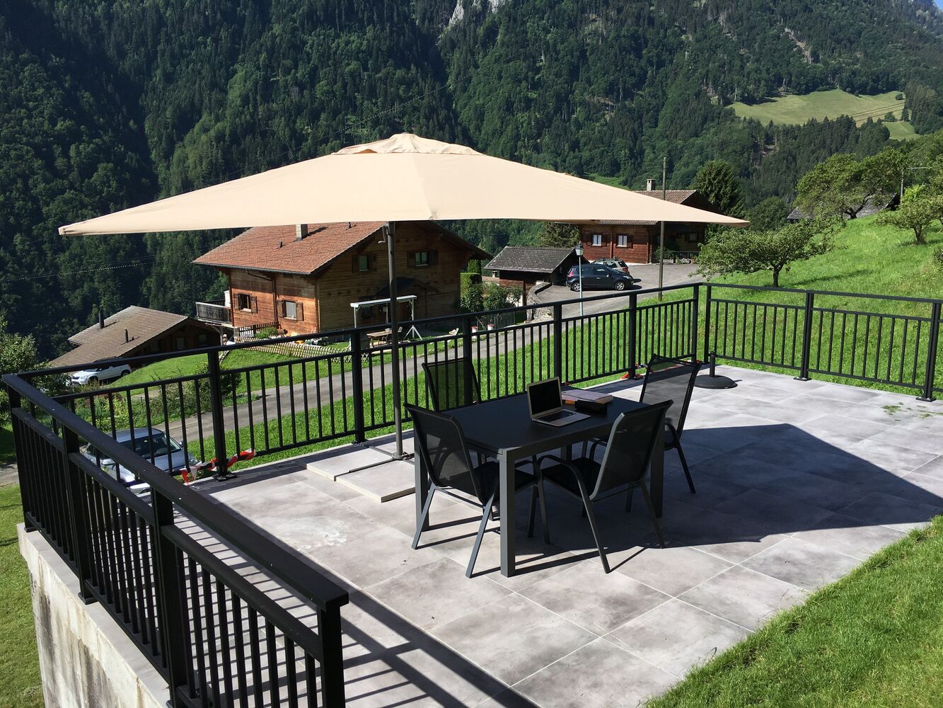 Bergterrasse mit Esstisch und Sonnenschirm