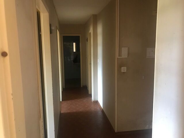 Flur mit Blick in einen dunkleren Durchgang