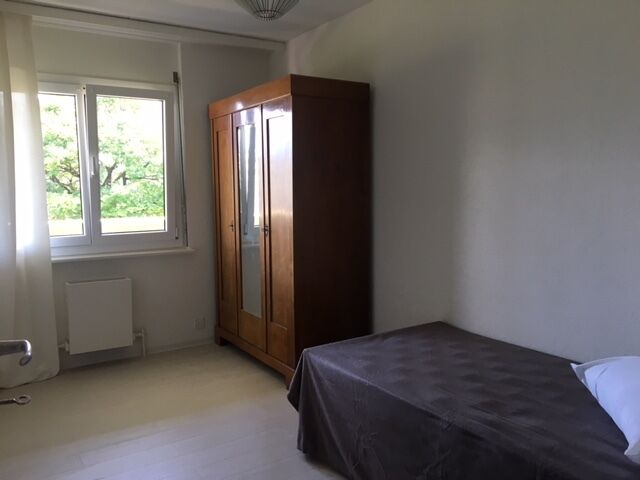 Schlichtes Schlafzimmer mit Fenster und Kleiderschrank