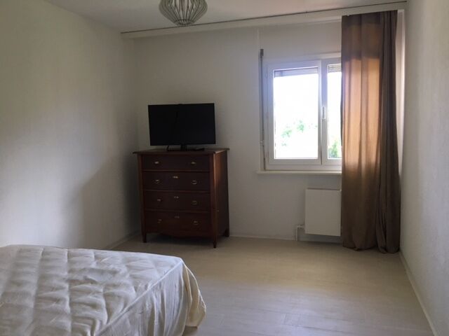 Schlichtes Schlafzimmer mit Fenster und Kommode