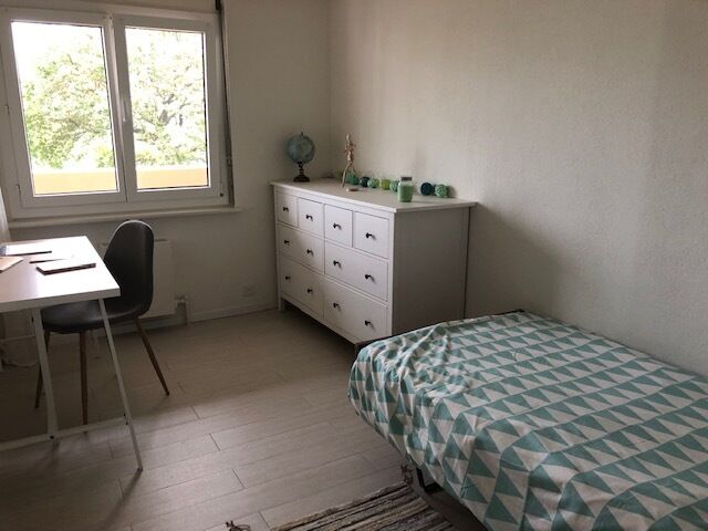 Helles Schlafzimmer mit Fenster und Kommode