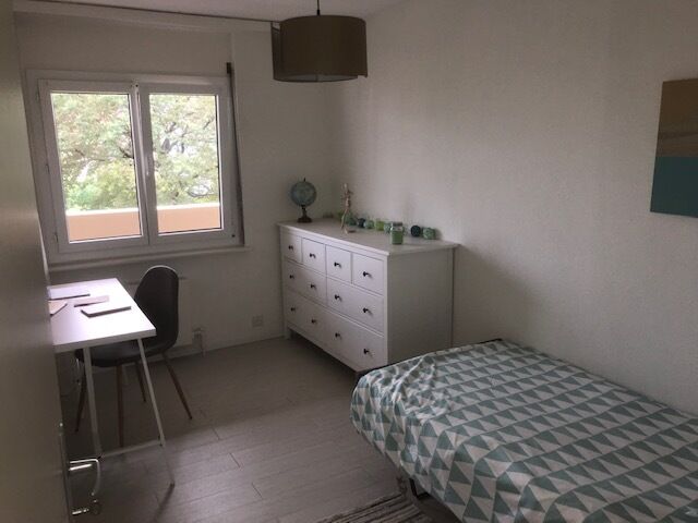 Helles Schlafzimmer mit Einzelbett und Schreibtisch