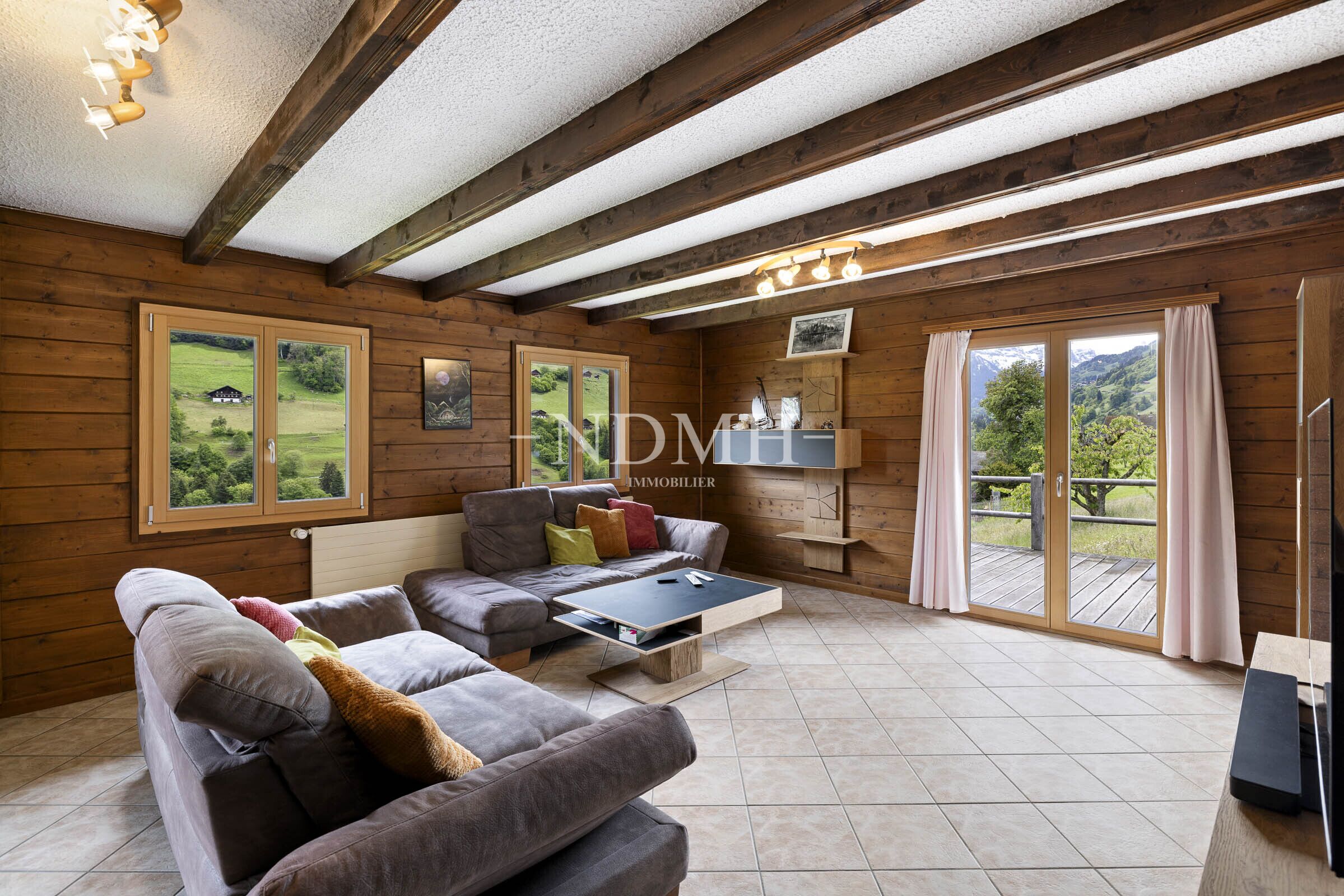 Gemütliches Wohnzimmer mit Holzverkleidung und Bergblick