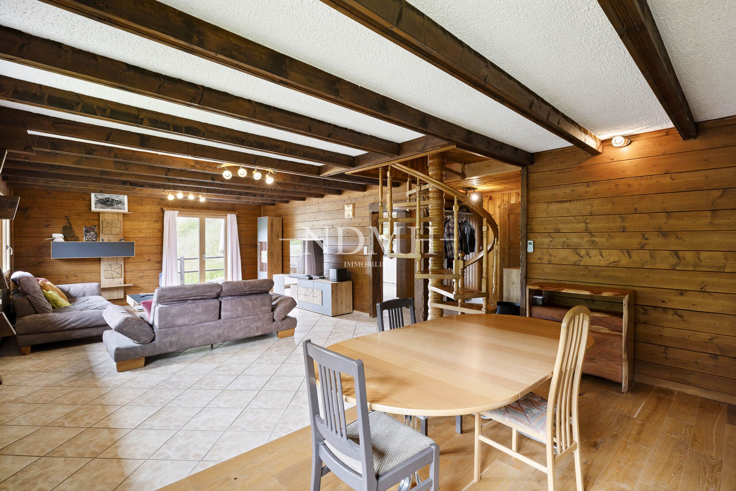 Gemütliches Wohnzimmer mit Essbereich und Holzverkleidung
