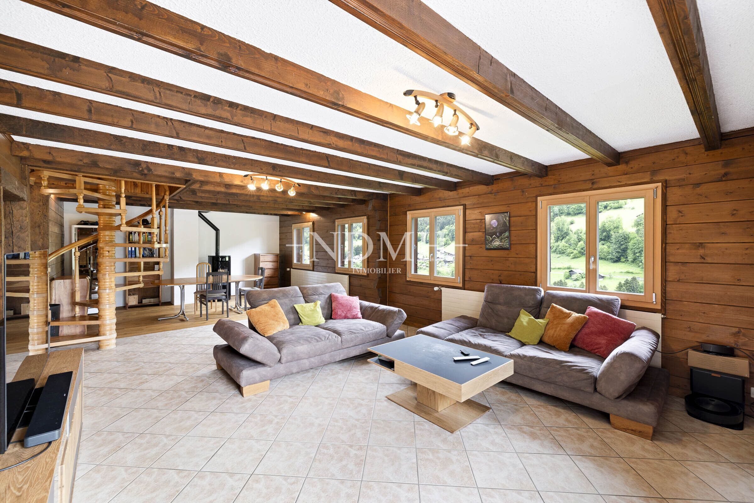 Gemütliches Wohnzimmer mit Holzdecke und Bergblick