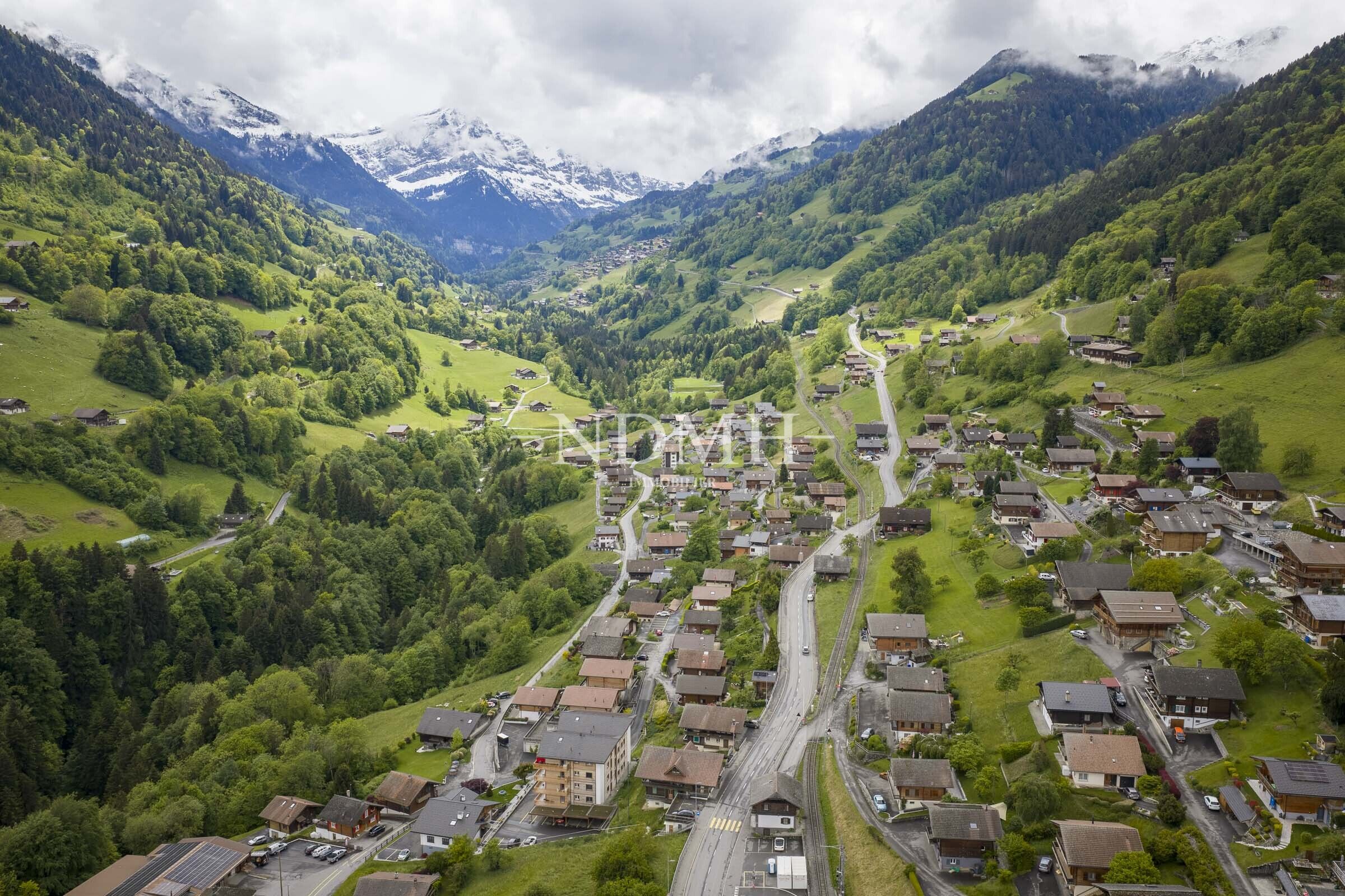 Luftaufnahme eines alpinen Tals mit Siedlung