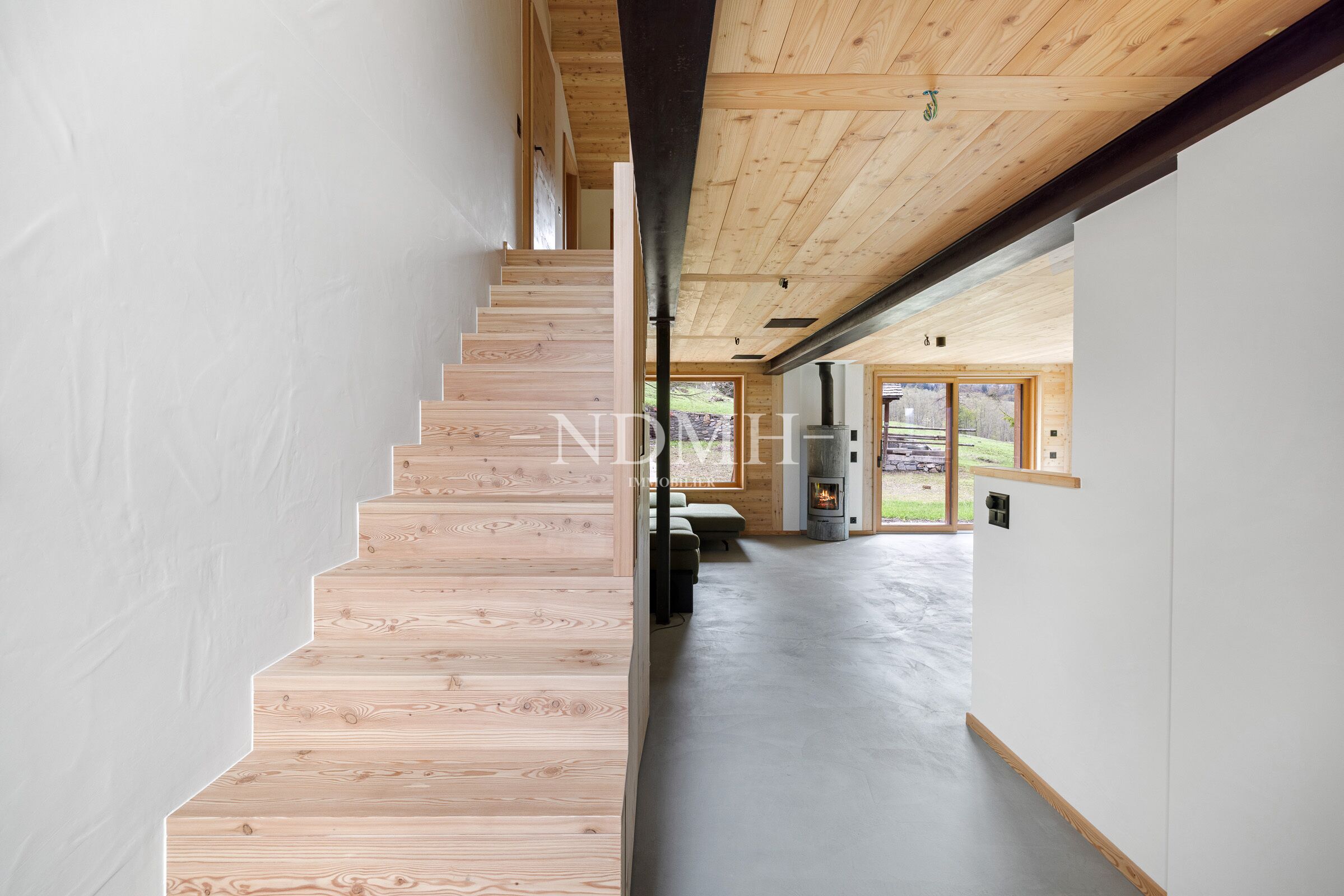 Offener Wohnbereich mit Holztreppe und Kamin