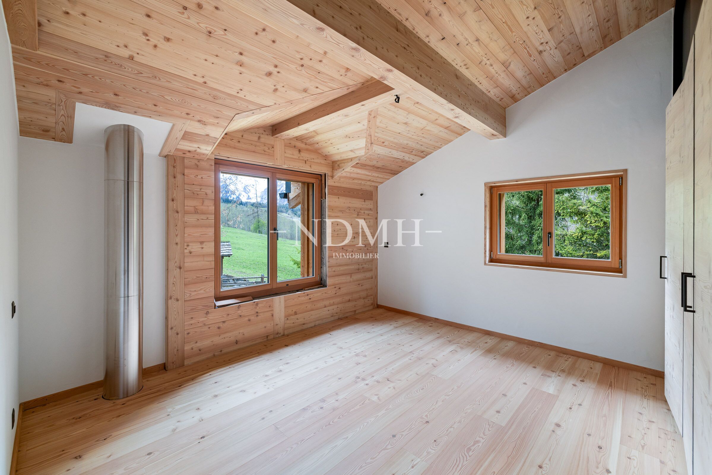Heller Dachraum mit Holzverkleidung und Ausblick ins Grüne