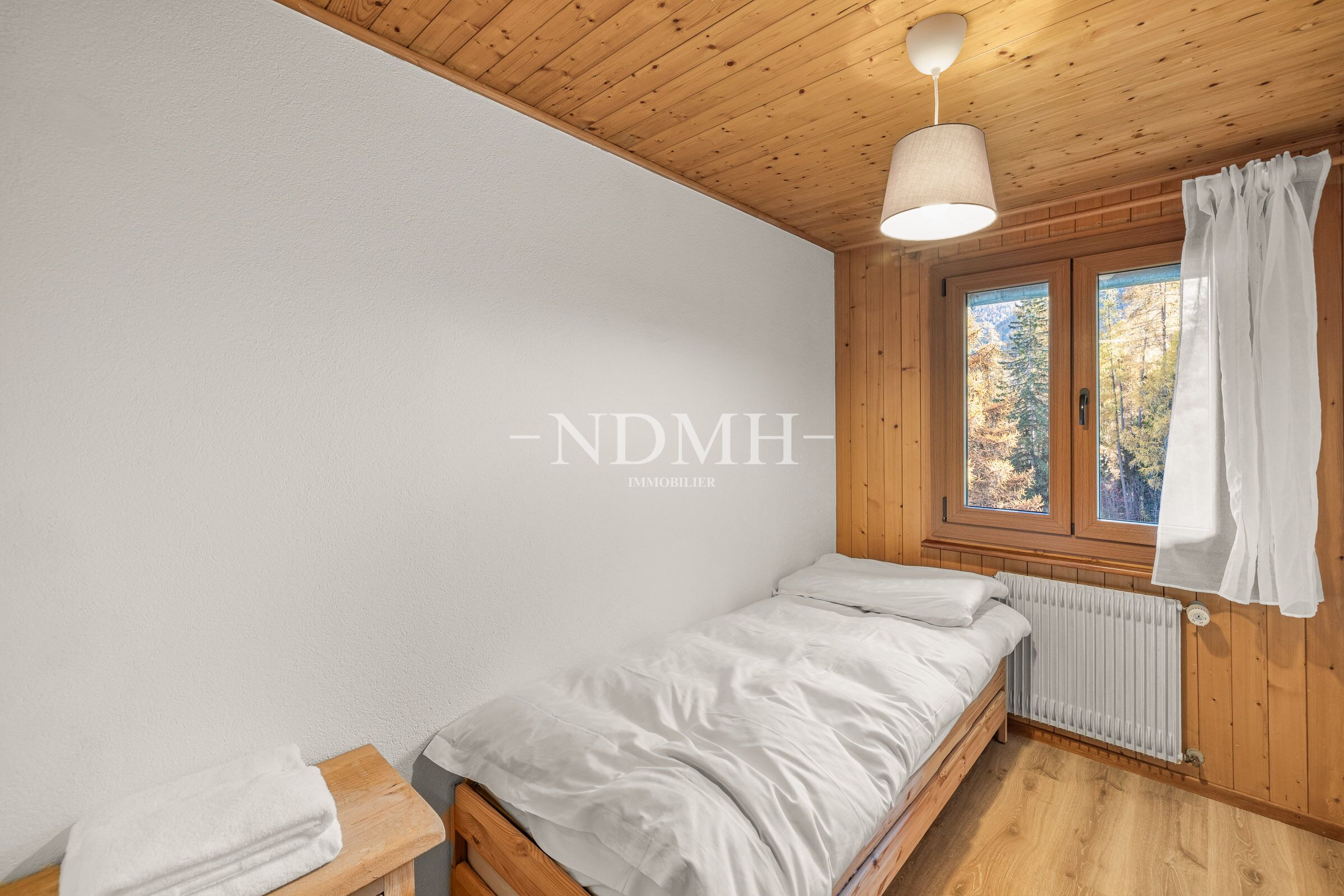 Kleines Holz-Schlafzimmer mit Blick ins Grüne