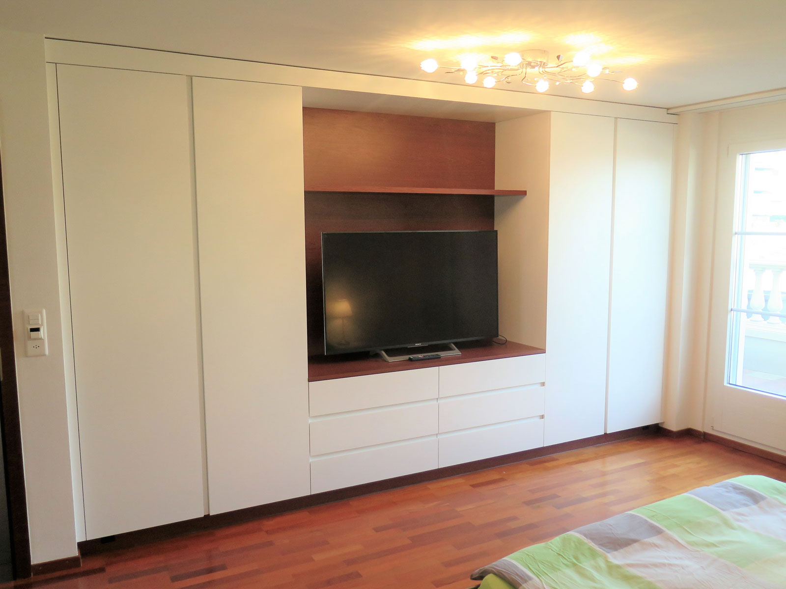 Schlafzimmer mit Einbauschrank und TV-Wand