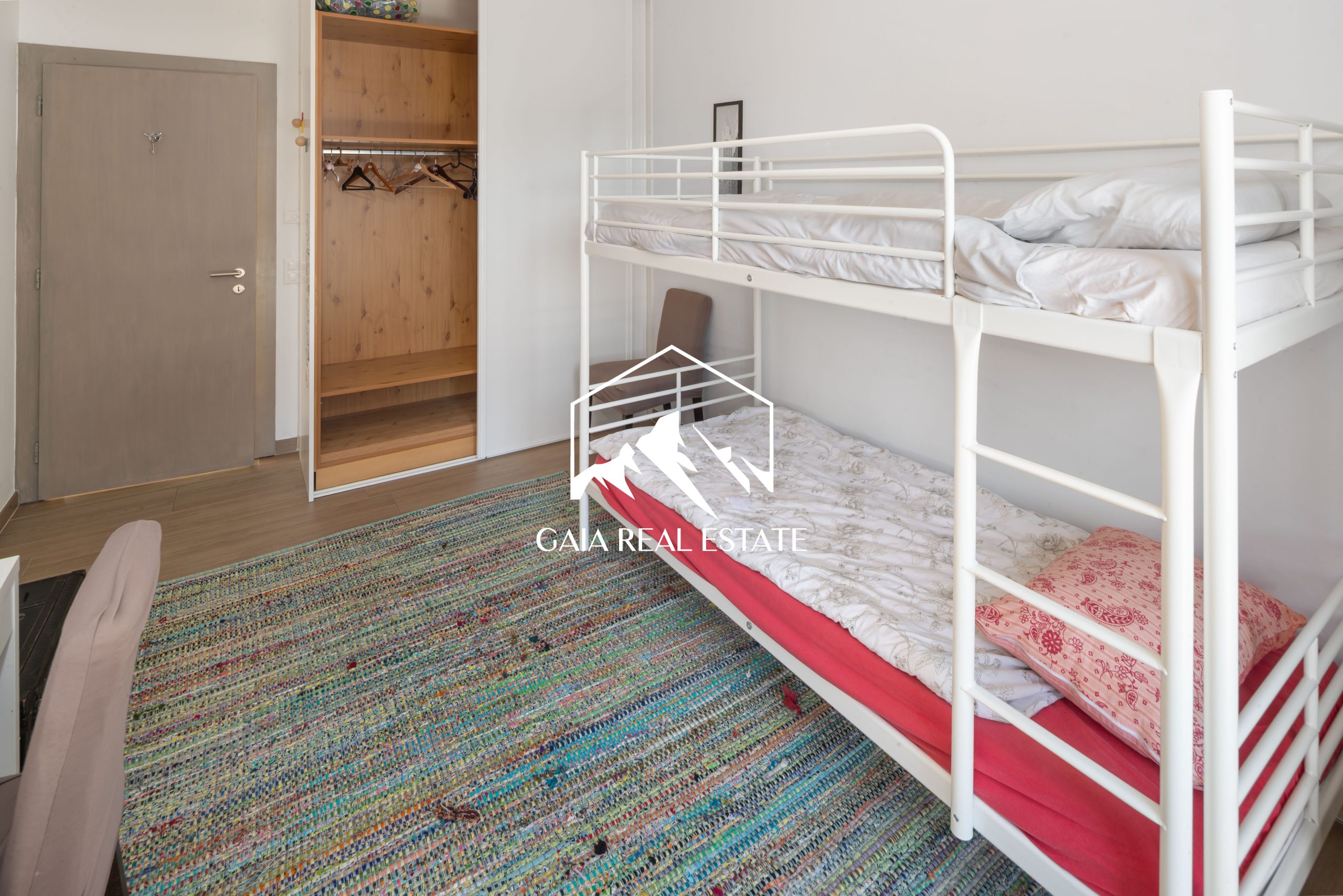 Kinderzimmer mit Etagenbett und offenem Kleiderschrank