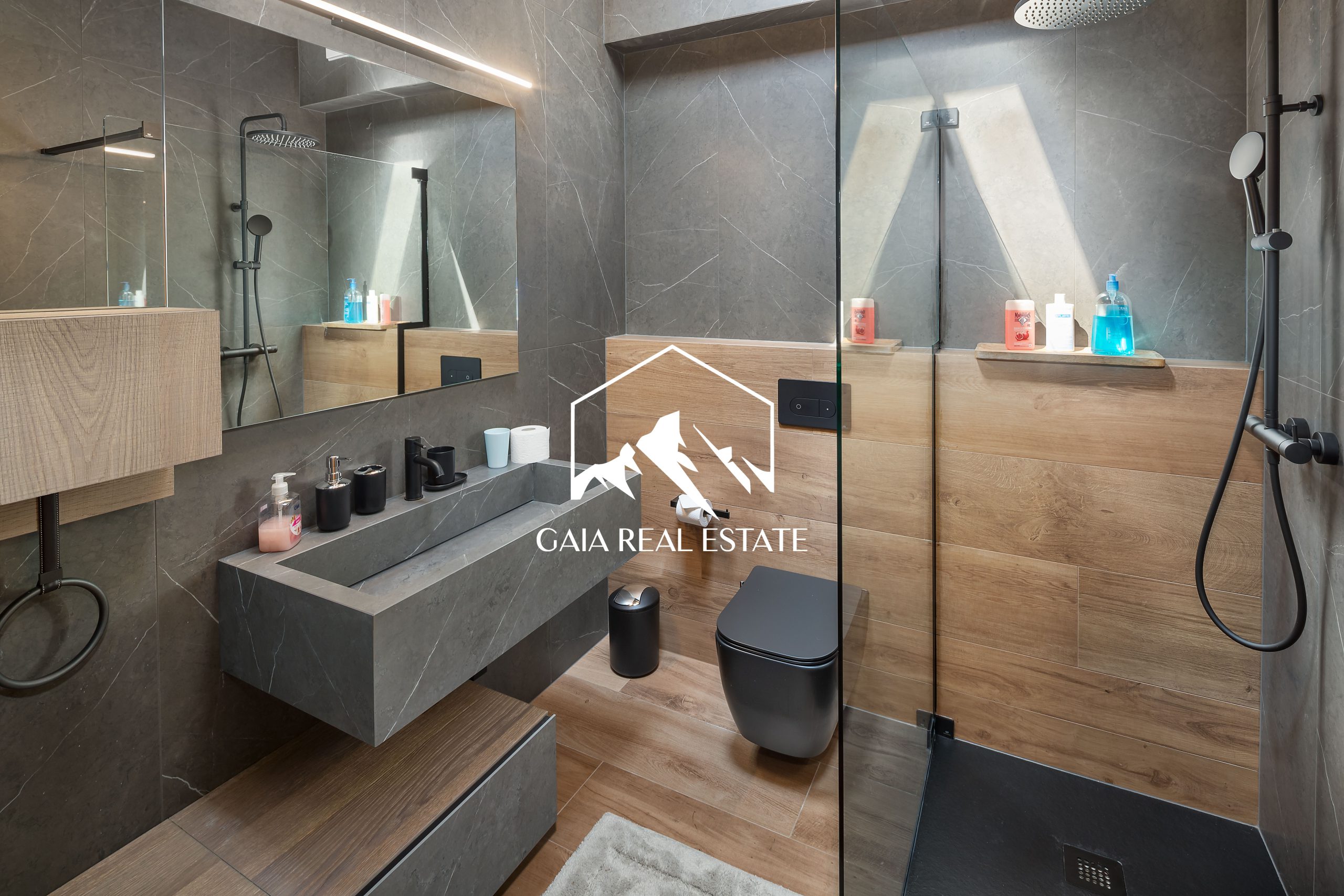 Modernes Badezimmer mit dunkler Steinoptik und Holzakzenten