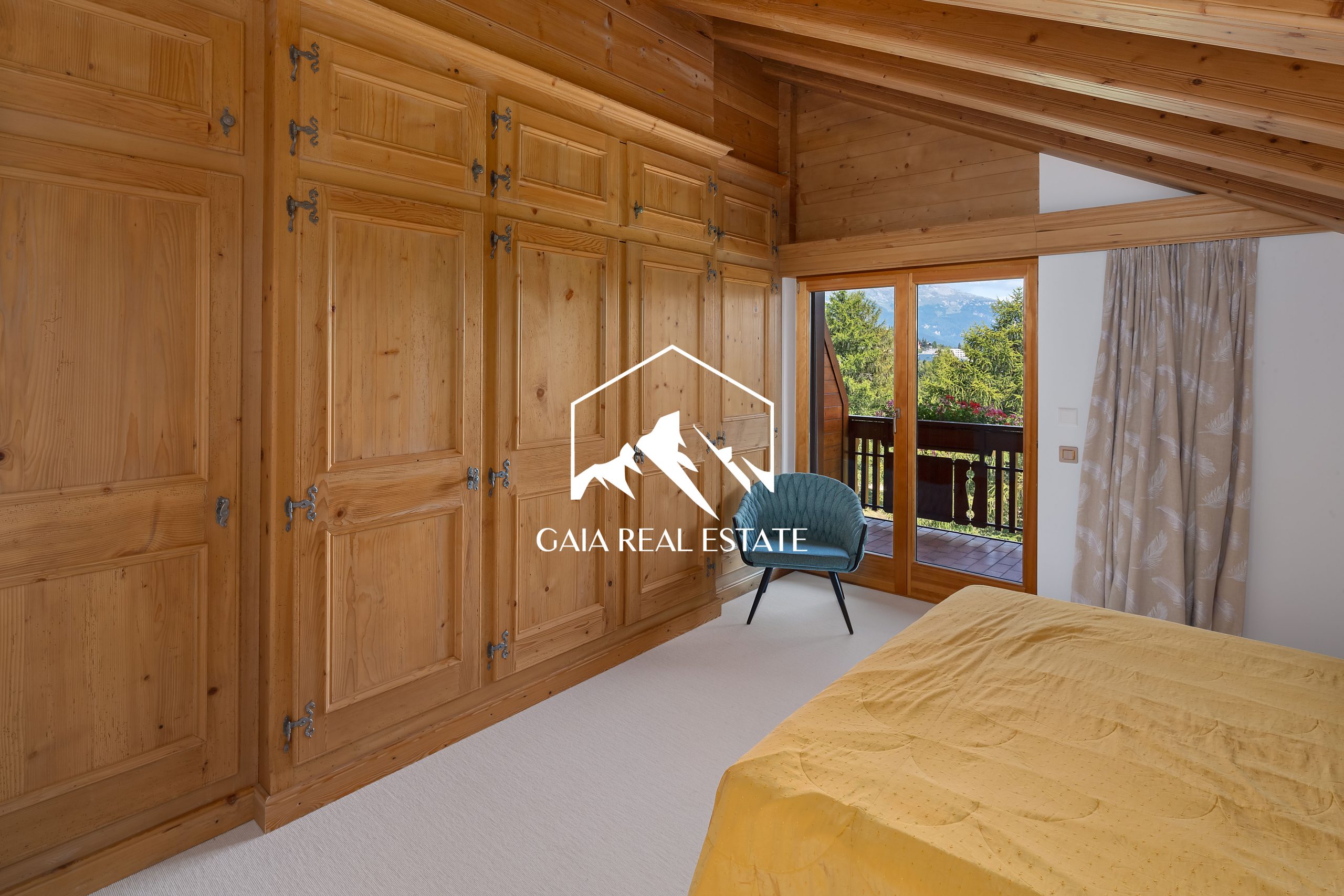 Gemütliches Schlafzimmer mit Holzverkleidung und Balkonblick