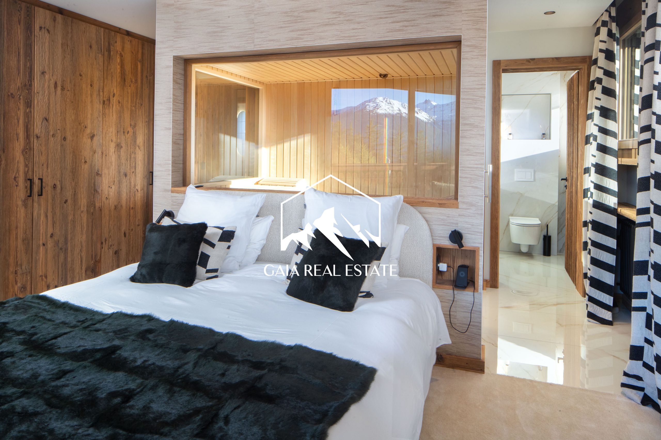 Modernes Schlafzimmer mit Badzugang und Bergblick