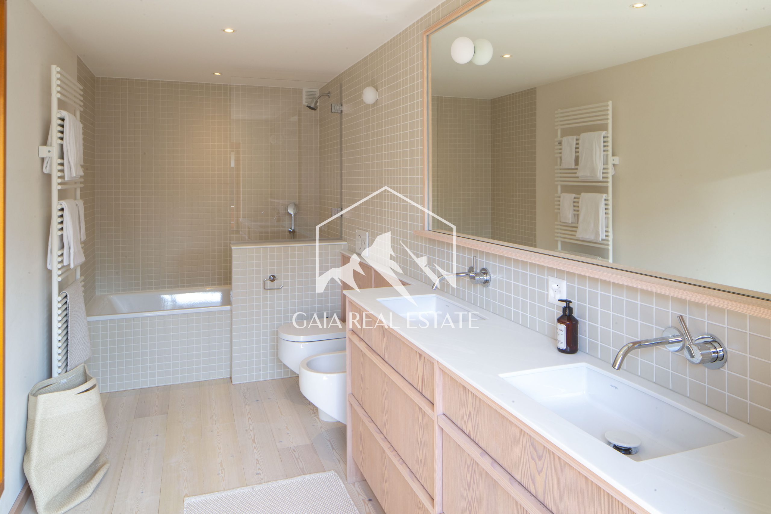 Helles Badezimmer mit Doppelwaschbecken und Badewanne